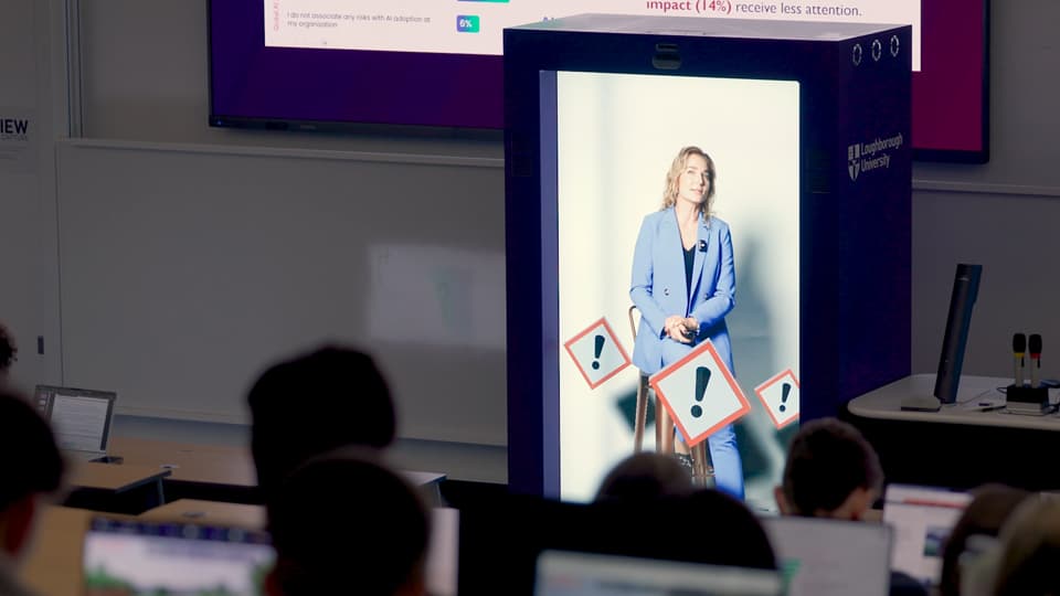 A female academic speaks to a lecture theatre of students in holographic form.